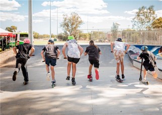 Kids on scooters at a skatepark